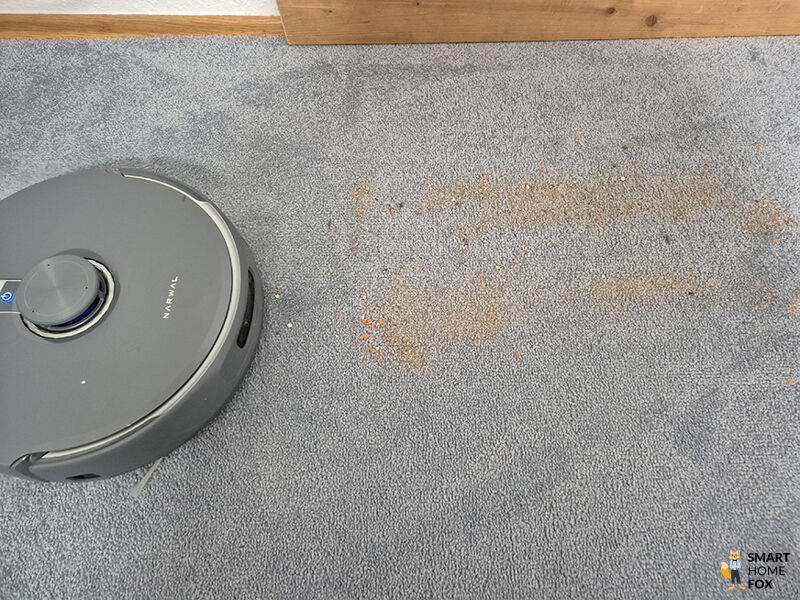 Der Narwal Freo Z10 Ultra beim Reinigungstest mit Sand auf Teppich.